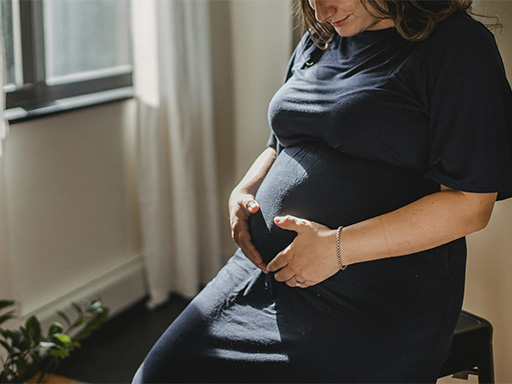 Pregnant woman holding her belly in a loving way, represents how you can find support for pregnancy, prenatal and postpartum periods thought specialized therapy in Deerfield. IL.