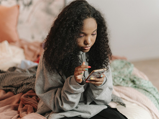Teen girl scrolling on her phone, represent the additional challenges social media can bring to teens lives today.