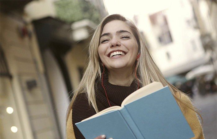 Young college girl with a book, representing the school path to becoming a counselor.