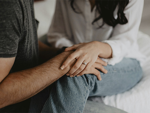 Hands of a couple wearing wedding rings represent how partners can work on their relationship together with the support of a certified Gottman therapist.