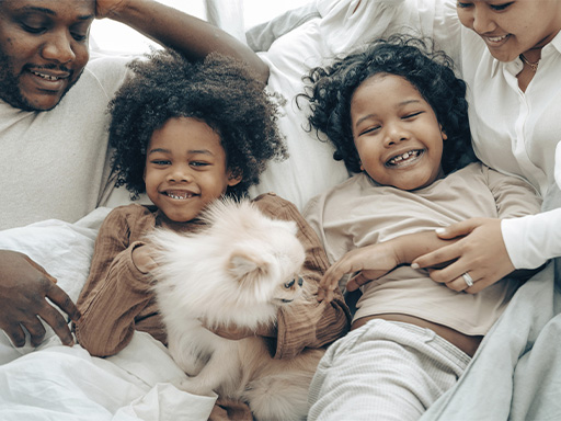 Cheerful family having fun together with their dog, represents how a family counselor in Deerfield, IL can help you feel closer and happy together.