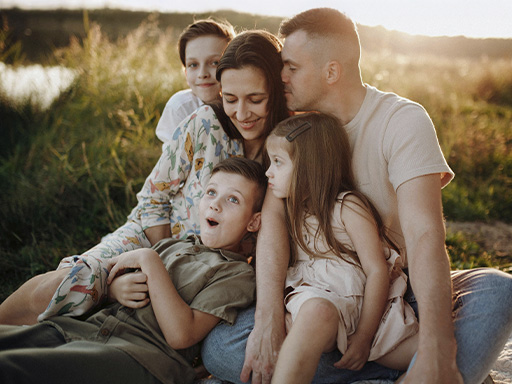 Happy family together in a picnic, representing how a family therapist can work with you to help your family feel connected again.