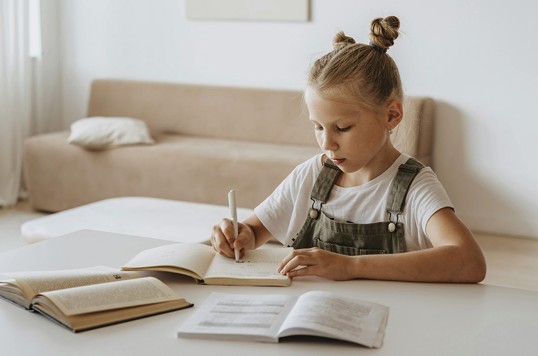 Girl writing on a notebook, represents the story of how our therapist Claire Manley became a counselor.