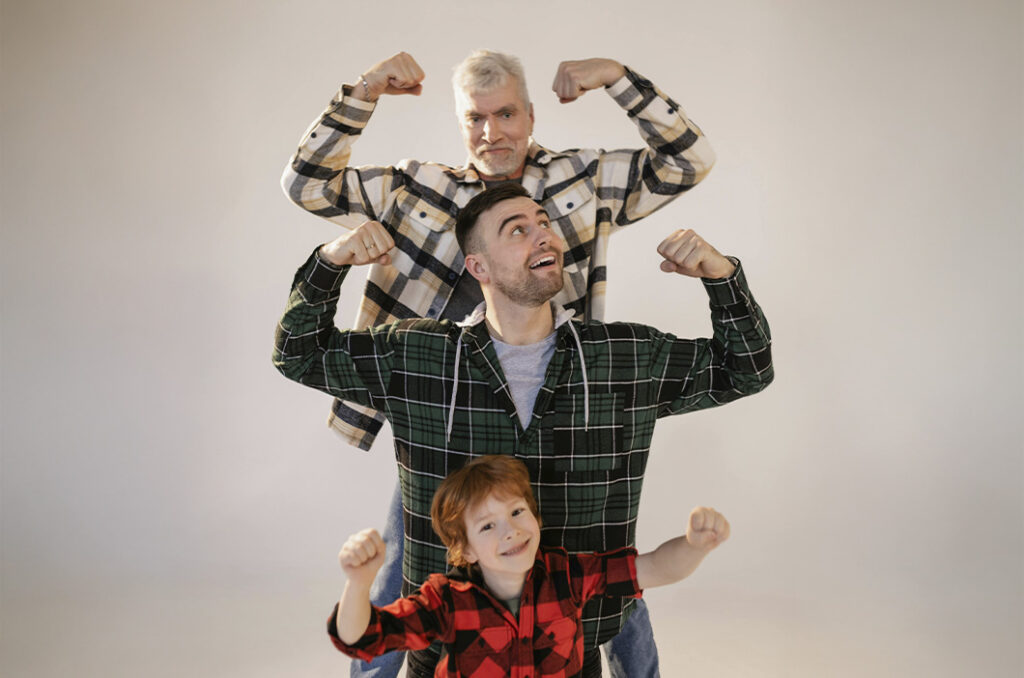 Grandfather, father, and grandson posing to show off their muscles, representing how the masculinity culture affects men's mental health and relationships.