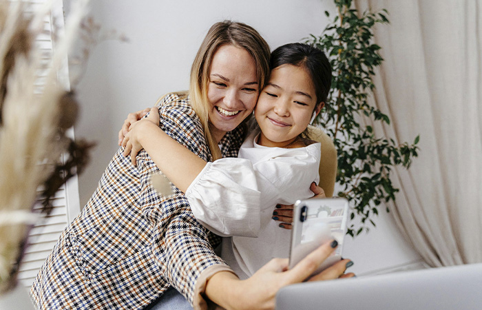 Stepmom and daughter taking cute selfie together, representing how stepparents can work to build trust of children of divorce and connect.