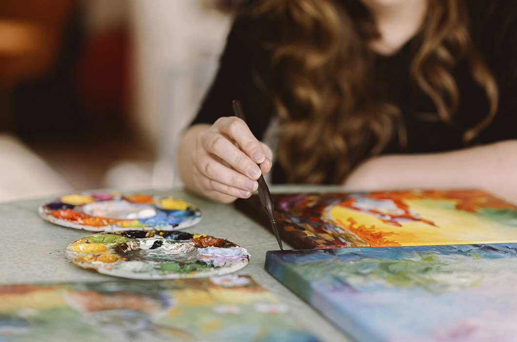 Woman painting with a brush, represents the journey of how our therapist Claire Reiser became a counselor.