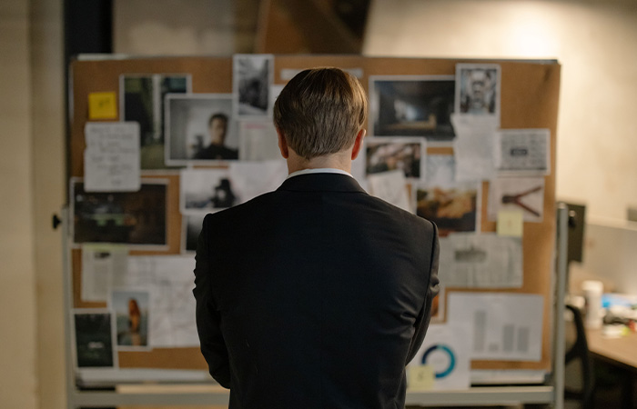 Detective looking at a board with the crime evidence, represents how the curiosity in psychology started by watching crime shows.