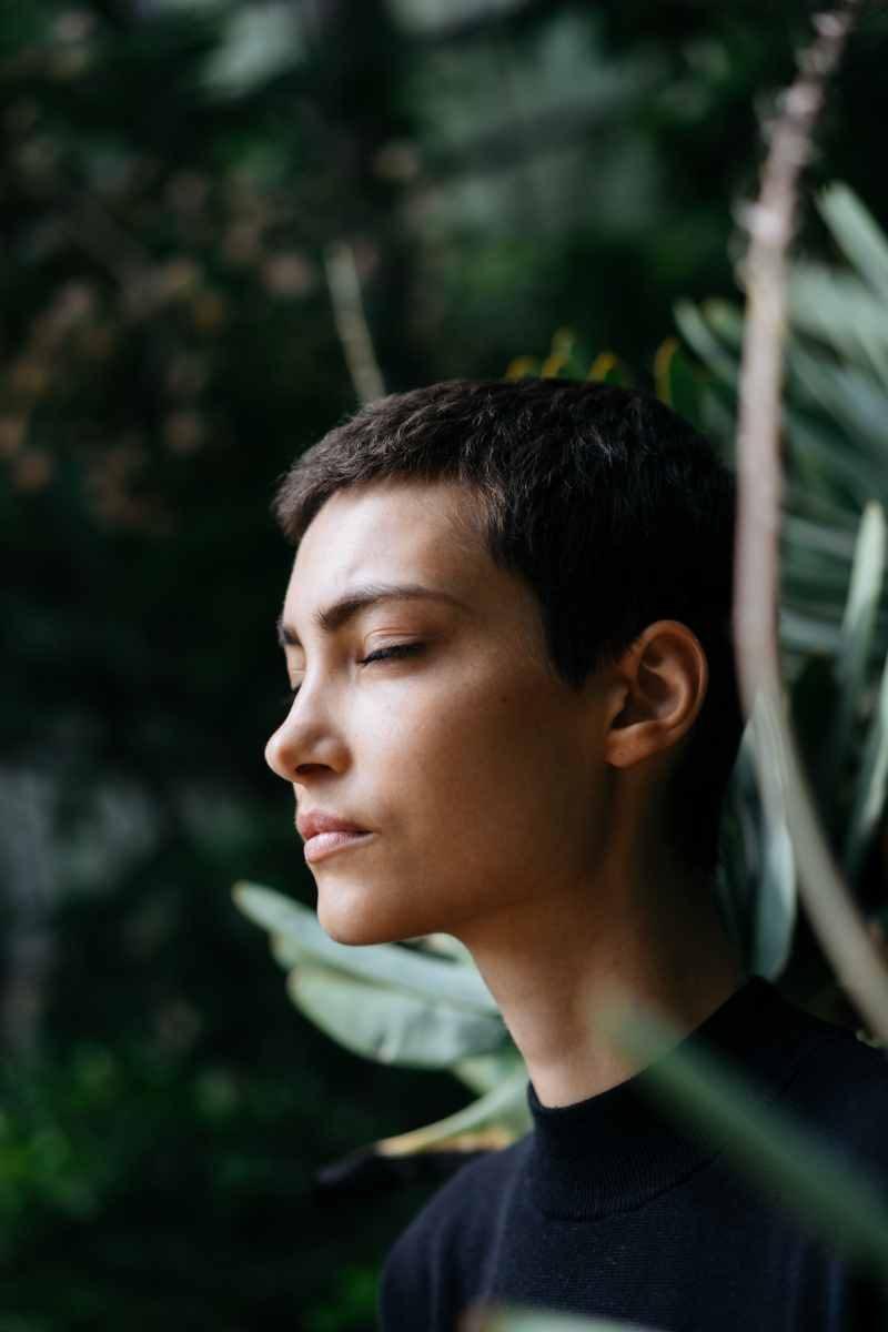 young man meditating in forest